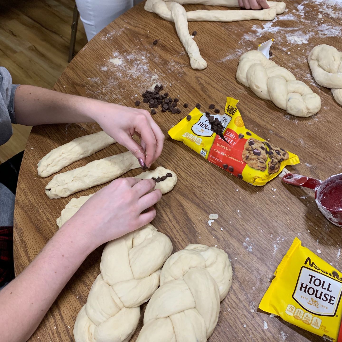 A K.U. student places chocolate chips into raw challah bread dough